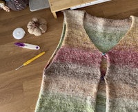 a knitted vest on a wooden table