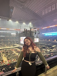 a woman standing on a railing in a stadium