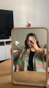 a woman taking a selfie in front of a mirror