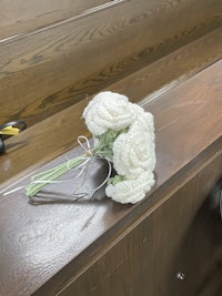 a bouquet of white flowers sits on a wooden table