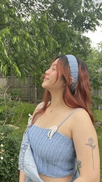 a woman wearing a blue crop top and denim shorts