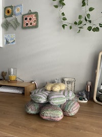 a room with several crocheted pillows on the floor