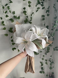 a person holding a bouquet of white lilies