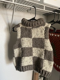 a knitted sweater hanging on a clothes rack